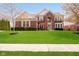 Charming red brick two-story home with a well-manicured lawn and beautiful landscaping at 13933 Wildcat Dr, Carmel, IN 46033
