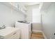 Bright laundry room features wood floors, large sink, modern washer and dryer, a window, and practical shelving at 13933 Wildcat Dr, Carmel, IN 46033