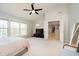 A spacious main bedroom with carpeted floor, ceiling fan, tv, lounge chair, and natural light at 13933 Wildcat Dr, Carmel, IN 46033