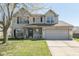 Charming two-story home with a well-manicured lawn, inviting porch, and an attached two-car garage at 13971 Bruddy Dr, Fishers, IN 46038