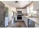 Well-lit kitchen featuring stainless steel appliances, ample counter space, white cabinets, and stylish flooring at 13971 Bruddy Dr, Fishers, IN 46038