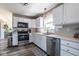 Well-lit kitchen features stainless steel appliances, white cabinets, and a patterned floor mat at 13971 Bruddy Dr, Fishers, IN 46038