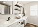 Stylish bathroom featuring double sinks with black fixtures, floating shelves, and decorative mirrors at 15037 Rutherford Dr, Westfield, IN 46074