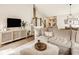 Cozy living room featuring a sectional sofa, stylish cabinet, decor, and an open staircase at 15037 Rutherford Dr, Westfield, IN 46074
