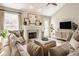 Cozy living room featuring a fireplace, neutral decor, and ample natural light, perfect for relaxation at 15037 Rutherford Dr, Westfield, IN 46074