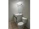 Neutral bathroom featuring a white vanity, sink, and toilet, complemented by modern lighting at 1517 N Gladstone Ave, Indianapolis, IN 46201