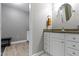 Well-lit bathroom with a granite countertop vanity, round mirror and neutral wall and floor colors at 1520 Norfolk Dr, Zionsville, IN 46077
