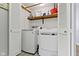 Laundry room with modern, white, front-load washer and dryer appliances and open shelving for easy storage at 1520 Norfolk Dr, Zionsville, IN 46077