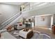 Bright living room showcasing soaring ceilings, a staircase, and an open floor plan leading to the kitchen at 1520 Norfolk Dr, Zionsville, IN 46077