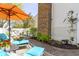 Cozy patio featuring lounge chairs with orange umbrella, brick chimney and white siding at 1520 Norfolk Dr, Zionsville, IN 46077