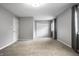 Spacious bedroom with neutral carpet, white trim, a walk-in closet, and a window with decorative curtains at 156 Aspen Way, Carmel, IN 46032