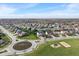 Wide aerial view of a residential neighborhood showing street layout, landscaping, community playground, and green spaces at 15723 Myland Dr, Noblesville, IN 46062