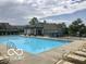 Community pool with ample seating and lounging options on a sunny day with clear blue water and a covered area at 15723 Myland Dr, Noblesville, IN 46062