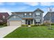 Charming two-story home with a well-maintained lawn, complemented by mature shrubs and a spacious two-car garage at 15723 Myland Dr, Noblesville, IN 46062