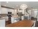 Bright open concept kitchen with white cabinets, stainless steel appliances and a wooden dining table at 15723 Myland Dr, Noblesville, IN 46062