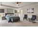 Serene main bedroom with tray ceiling, large windows, plush carpeting, and cozy seating area for relaxation at 15723 Myland Dr, Noblesville, IN 46062