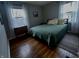 Cozy bedroom featuring hardwood floors, comfortable bed, and natural light from the windows at 1624 N Whittier Pl, Indianapolis, IN 46218
