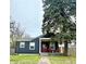 Charming home featuring a covered porch with red chairs and a well-maintained lawn at 1624 N Whittier Pl, Indianapolis, IN 46218