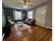 Comfortable living room with hardwood floors, large windows, and a stylish gray sofa at 1624 N Whittier Pl, Indianapolis, IN 46218