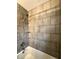 Modern shower featuring tile walls, a rainfall showerhead, and built-in shelving at 1624 N Whittier Pl, Indianapolis, IN 46218