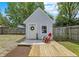 Backyard shed with small deck, decorative wreath, and outdoor seating creating an inviting space at 1629 N K St, Elwood, IN 46036