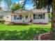 Inviting single-story home with a welcoming front porch and lush green lawn at 1629 N K St, Elwood, IN 46036