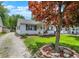 Charming single-story home featuring a well-kept lawn, American flag, and lovely landscaping around the trees at 1629 N K St, Elwood, IN 46036