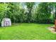 Spacious backyard featuring lush greenery, fencing, and a quaint storage shed at 1697 Stacy Lynn Dr, Indianapolis, IN 46231