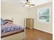 Bright bedroom with wood floors, ceiling fan and a sunlit window overlooking the outdoors at 1697 Stacy Lynn Dr, Indianapolis, IN 46231