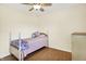 Cozy bedroom features wood floors, ceiling fan, and warm, inviting light at 1697 Stacy Lynn Dr, Indianapolis, IN 46231