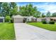 Well-kept single-story home boasts a lush green lawn and a long driveway to the attached garage at 1697 Stacy Lynn Dr, Indianapolis, IN 46231