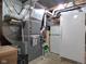Basement utility area with a furnace, ductwork, and a secondary refrigerator providing functional and storage solutions at 1737 Friendship Dr, Indianapolis, IN 46217
