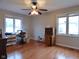 A large bedroom with hardwood floors, two windows, and a ceiling fan at 1737 Friendship Dr, Indianapolis, IN 46217