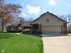 Charming brick home with a well-manicured lawn, covered porch, and a two-car garage at 1737 Friendship Dr, Indianapolis, IN 46217
