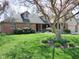 Beautifully landscaped front yard with lush green grass and a mature flowering tree at 1737 Friendship Dr, Indianapolis, IN 46217