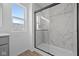 The bathroom has a glass enclosed shower with decorative tiles and a bright window at 2252 Marjorie Way, Shelbyville, IN 46176