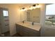 Bathroom with dual sinks, stylish lighting, and a large mirror over a stone countertop vanity at 2252 Marjorie Way, Shelbyville, IN 46176