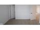 White-walled bedroom featuring neutral carpet, white trim, and multiple doors and entries at 2252 Marjorie Way, Shelbyville, IN 46176