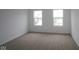 Bright bedroom featuring neutral carpet, white walls, white trim, and double windows at 2252 Marjorie Way, Shelbyville, IN 46176