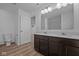 A modern bathroom features a double vanity with white countertop and wood-look floors at 2268 Marjorie Way, Shelbyville, IN 46176