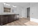 Modern bathroom with double vanity, dark wood cabinets, wood-look floors and bright lighting at 2268 Marjorie Way, Shelbyville, IN 46176