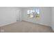 A bright bedroom features neutral carpet, white walls, and a window with neighborhood views at 2268 Marjorie Way, Shelbyville, IN 46176