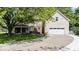 Inviting home featuring a side-entry garage, covered porch, and lush greenery on a sunny day at 244 W Admiral S Way, Carmel, IN 46032