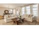 Bright living room featuring two white sofas, large windows, and a rustic wooden coffee table at 2548 Ruffian Dr, Westfield, IN 46074
