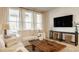 Cozy living room with a comfortable white sofa, large windows, and a rustic wooden coffee table at 2548 Ruffian Dr, Westfield, IN 46074