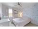 A serene bedroom with soft floral wallpaper, natural light and crisp, white furniture at 300 Wyndotte Dr, Carmel, IN 46032