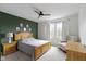 A beautifully decorated bedroom with wood furniture, a ceiling fan, and a green accent wall at 300 Wyndotte Dr, Carmel, IN 46032