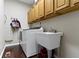 Well-equipped laundry room features a washing machine, sink and wood cabinets for storage at 300 Wyndotte Dr, Carmel, IN 46032