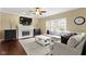 Cozy living room with a fireplace, neutral decor, large windows, and comfortable seating at 300 Wyndotte Dr, Carmel, IN 46032