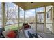 Relaxing screened-in porch with outdoor seating and a scenic view of the lake and yard at 300 Wyndotte Dr, Carmel, IN 46032